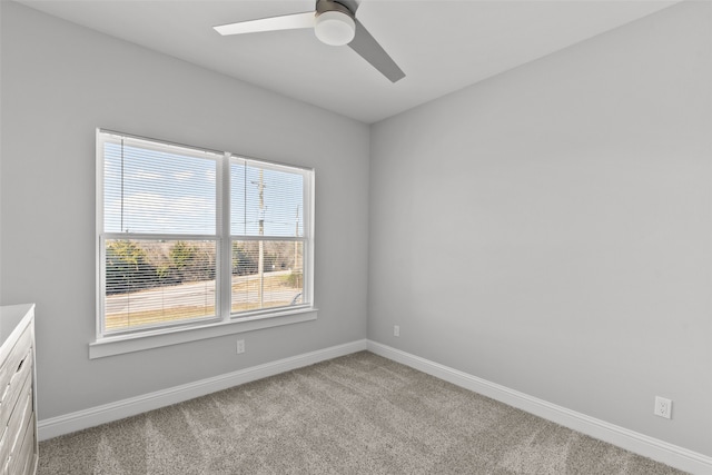 spare room with baseboards, light carpet, and ceiling fan