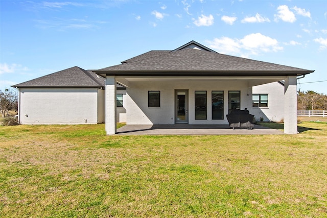 rear view of property with a patio, a yard, fence, and a shingled roof