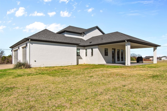 rear view of property with an attached garage, a lawn, brick siding, and a shingled roof