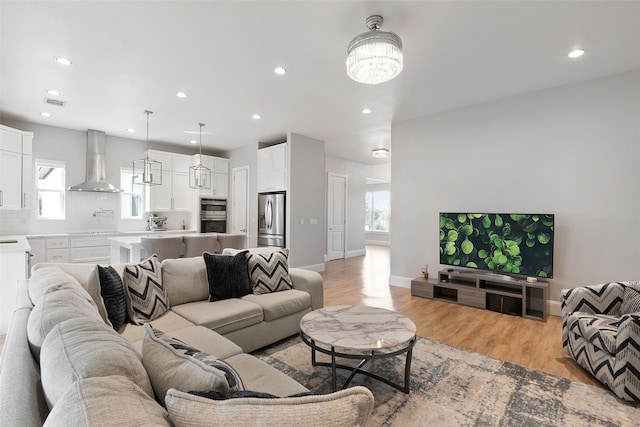 living room with visible vents, recessed lighting, and light wood-style floors