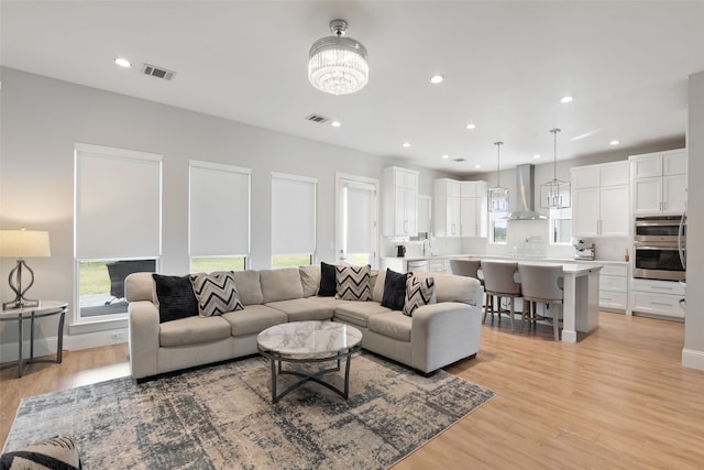 living room featuring recessed lighting, visible vents, and light wood finished floors