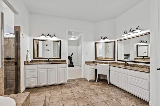 full bathroom featuring a shower stall, two vanities, and a sink