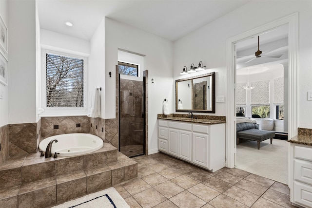 bathroom featuring plenty of natural light, a bath, vanity, and a tile shower