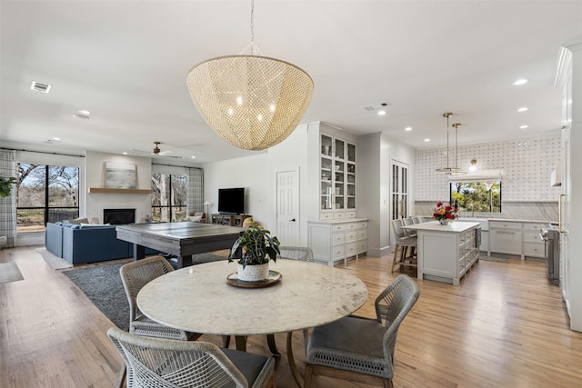 dining area with visible vents, recessed lighting, a fireplace, and light wood-type flooring