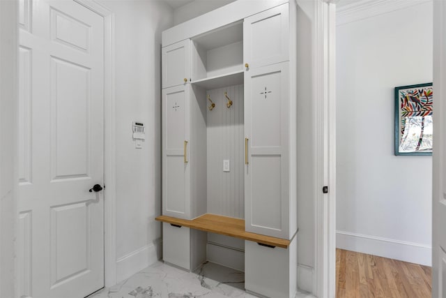 mudroom with baseboards and marble finish floor