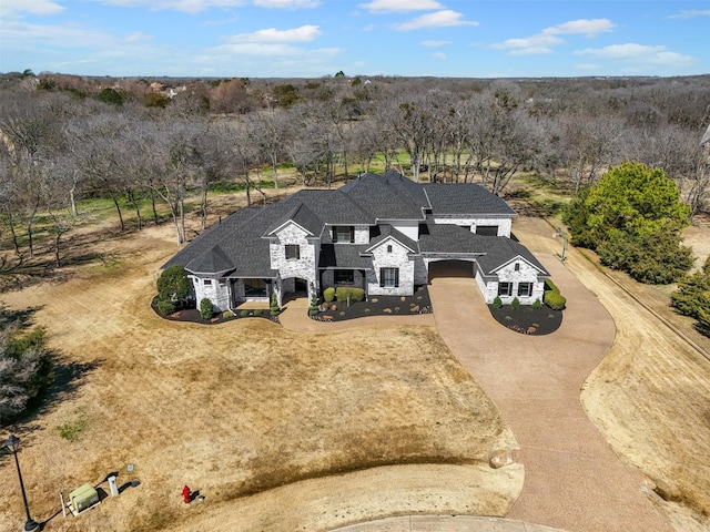 view of front of property featuring stone siding and driveway