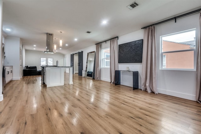 1818 Engle Ave, Dallas, TX 75224 - unfurnished living room featuring light wood-style floors, baseboards, recessed lighting, and a barn door