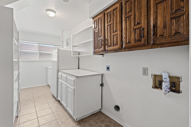 washroom with light tile patterned floors, cabinet space, baseboards, and hookup for an electric dryer