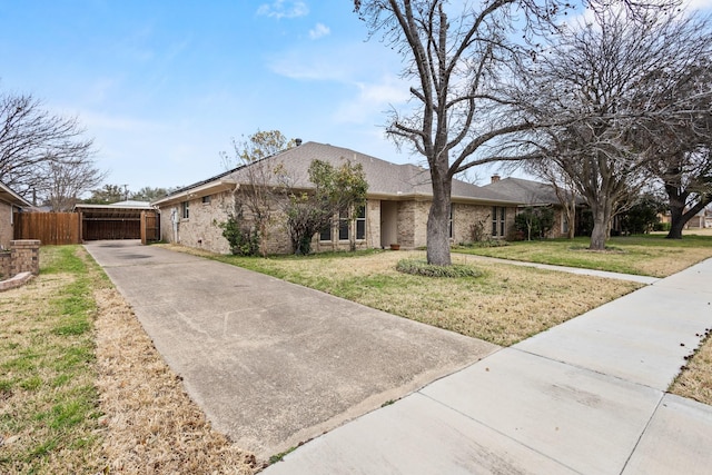 ranch-style home with brick siding, a chimney, a front yard, and fence