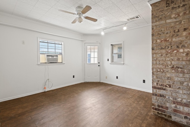 empty room featuring visible vents, cooling unit, baseboards, and dark wood finished floors