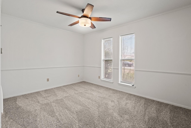 carpeted empty room with crown molding, baseboards, and ceiling fan