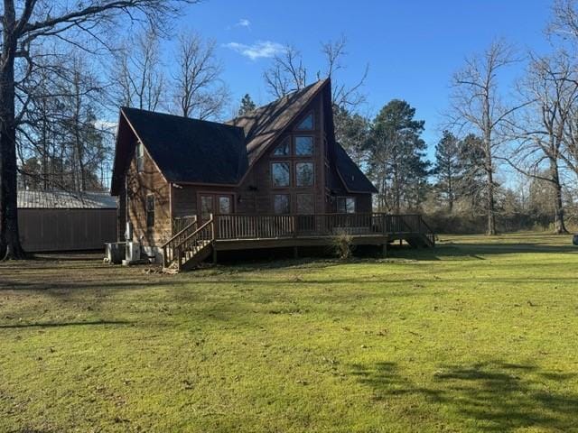 back of property with a wooden deck and a lawn