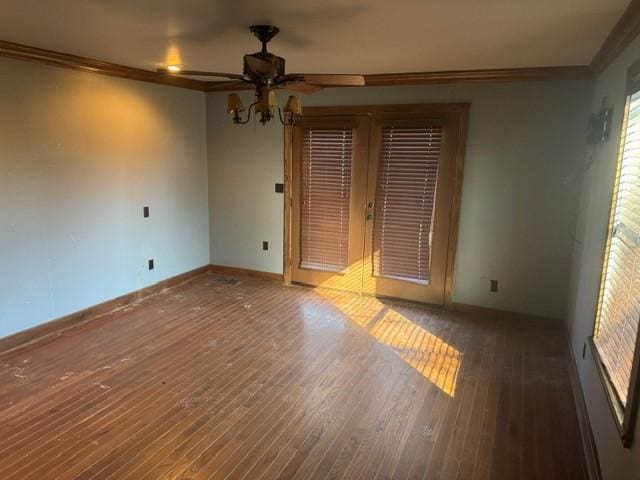 empty room featuring ornamental molding, baseboards, and hardwood / wood-style floors