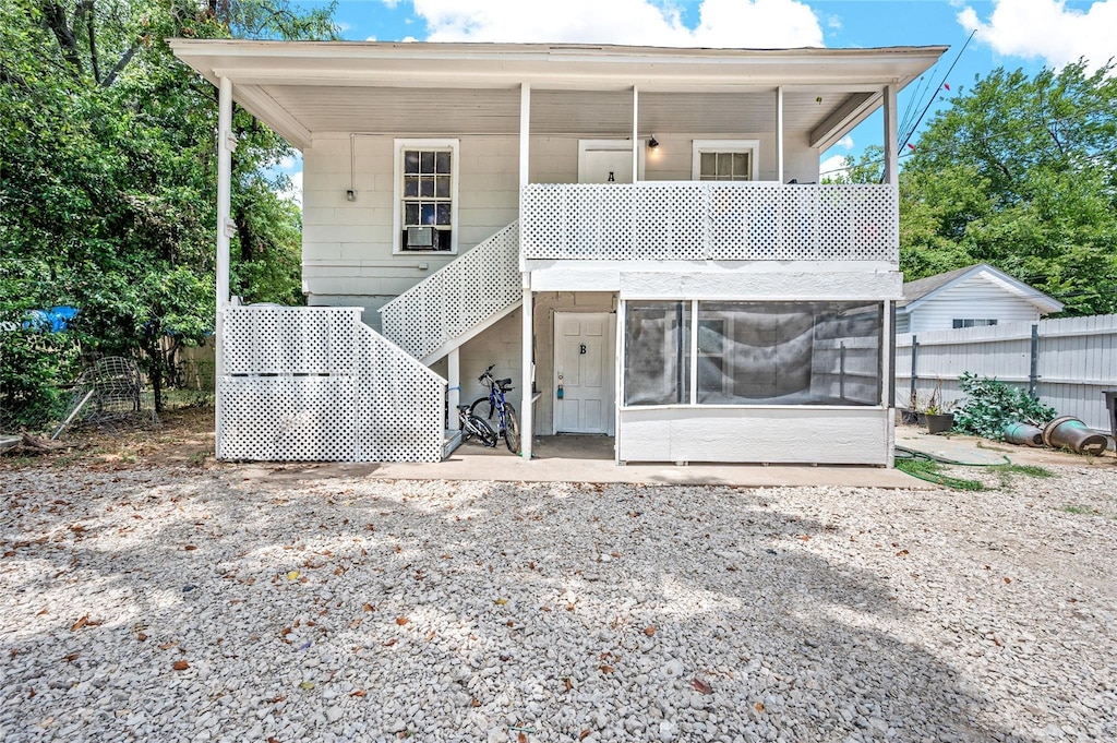 back of house with fence, stairs, and a sunroom