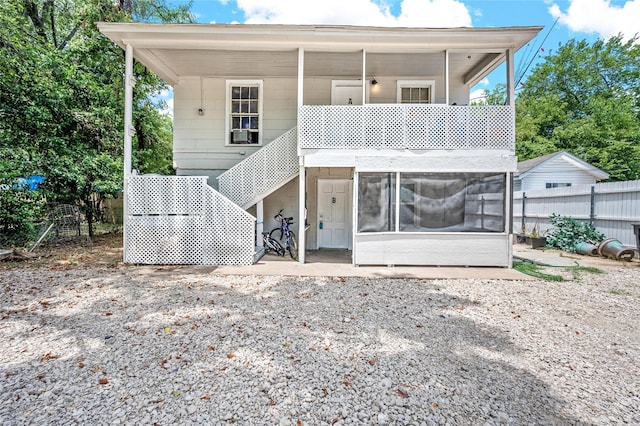 back of house with fence, stairs, and a sunroom