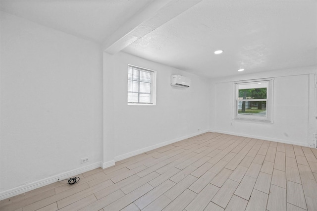 unfurnished room featuring a wall mounted air conditioner, baseboards, light wood-style flooring, and recessed lighting