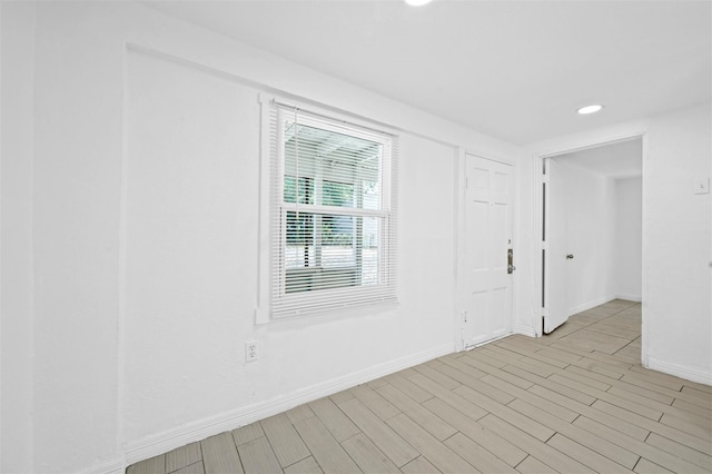 unfurnished room with recessed lighting, baseboards, and light wood-type flooring