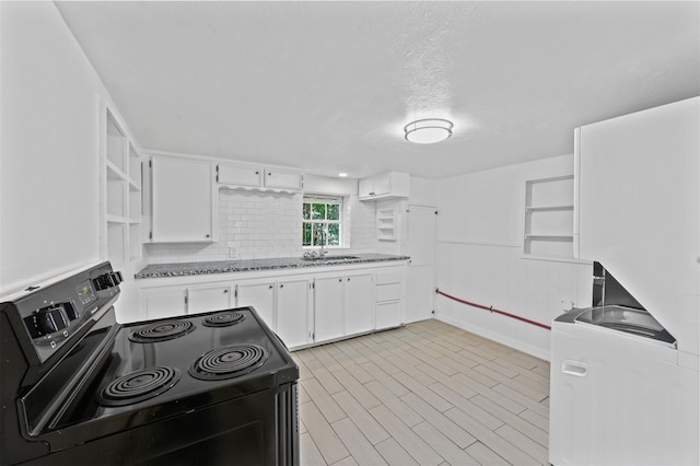 kitchen featuring light wood finished floors, open shelves, a sink, black range with electric stovetop, and white cabinetry