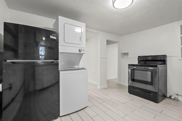 kitchen featuring white cabinetry, stacked washer / dryer, electric stove, and light wood-type flooring