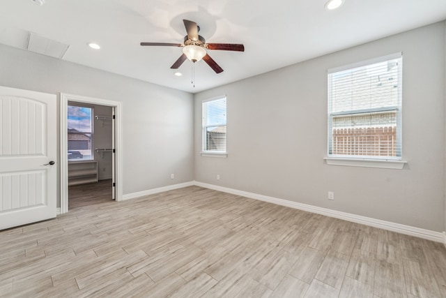 empty room featuring recessed lighting, baseboards, and light wood-type flooring