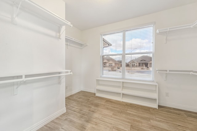 walk in closet with wood finished floors