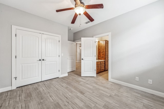 unfurnished bedroom with a closet, visible vents, light wood-type flooring, and baseboards