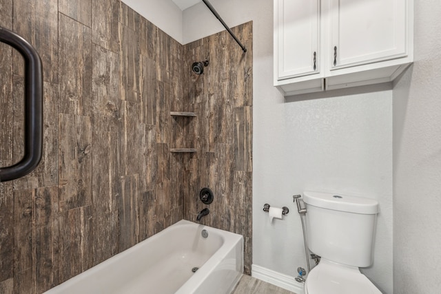 bathroom featuring shower / bathing tub combination, toilet, and baseboards