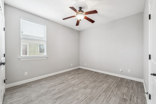 empty room featuring light wood finished floors, baseboards, and ceiling fan