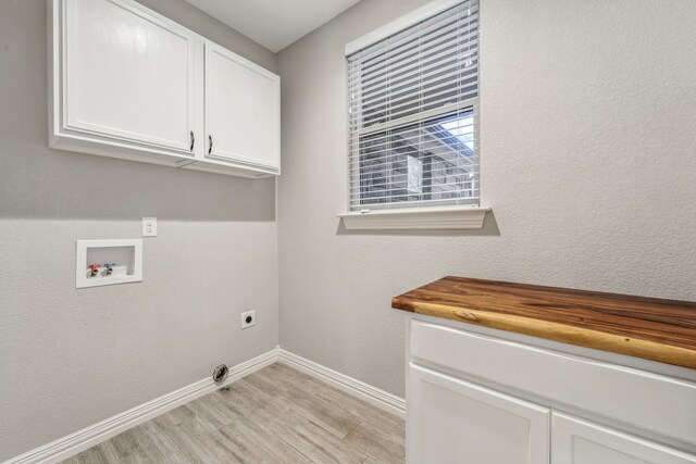 laundry room featuring baseboards, washer hookup, light wood-style floors, cabinet space, and electric dryer hookup