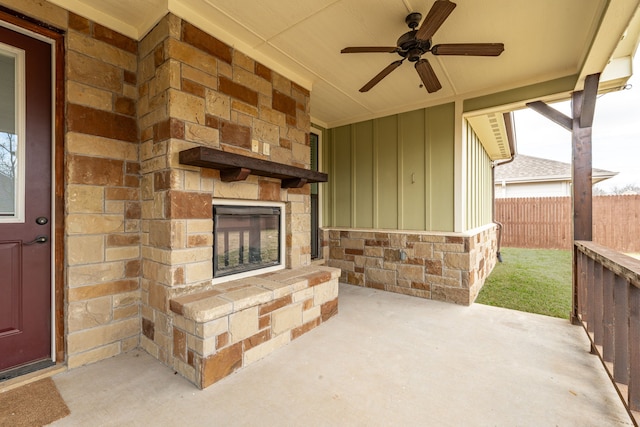 view of patio / terrace with an outdoor stone fireplace, a ceiling fan, and fence