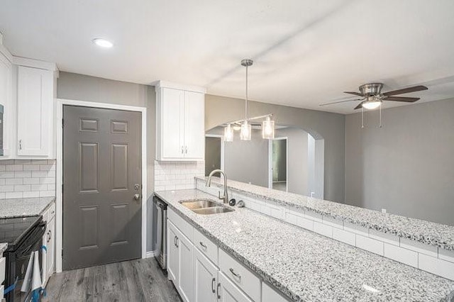 kitchen featuring a sink, wood finished floors, white cabinets, black / electric stove, and stainless steel dishwasher