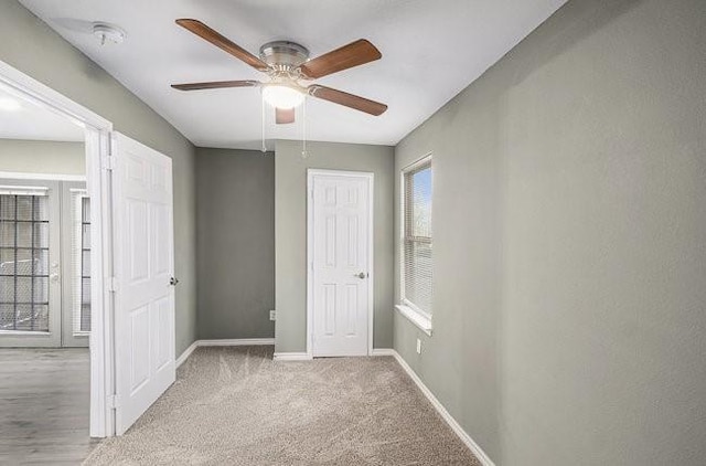 unfurnished bedroom featuring a closet, carpet flooring, a ceiling fan, and baseboards