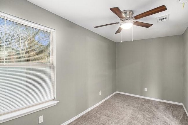 carpeted empty room featuring visible vents, baseboards, and a ceiling fan