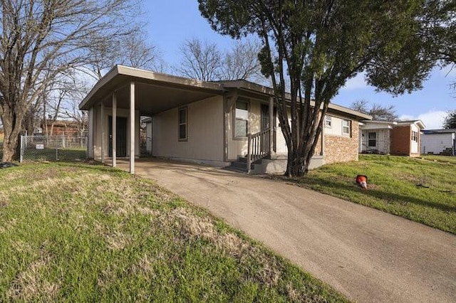 view of front of house with a carport, fence, a front yard, and driveway