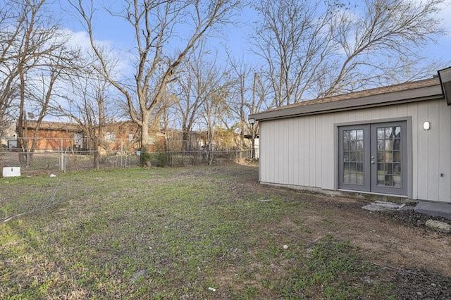 view of yard with french doors and fence