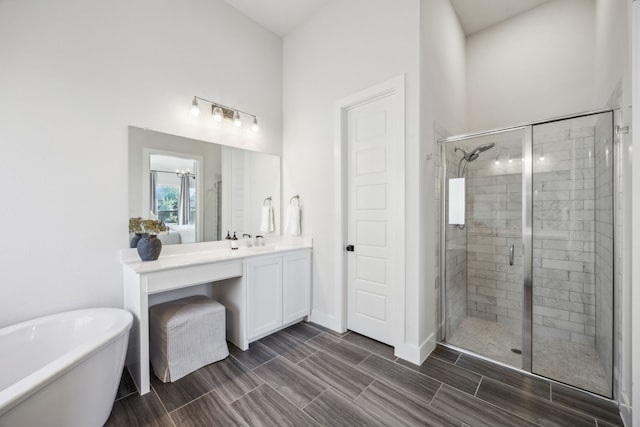 bathroom with vanity, a shower stall, a soaking tub, and wood tiled floor