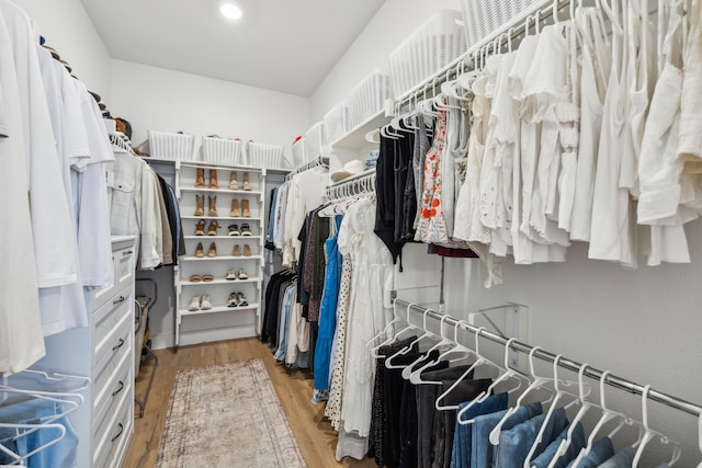 walk in closet with light wood-style floors