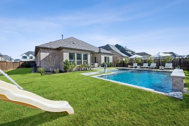 back of house with a lawn, a fenced backyard, a fenced in pool, brick siding, and a patio area