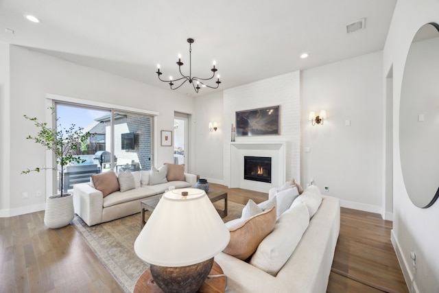 living room featuring recessed lighting, visible vents, wood finished floors, and a fireplace