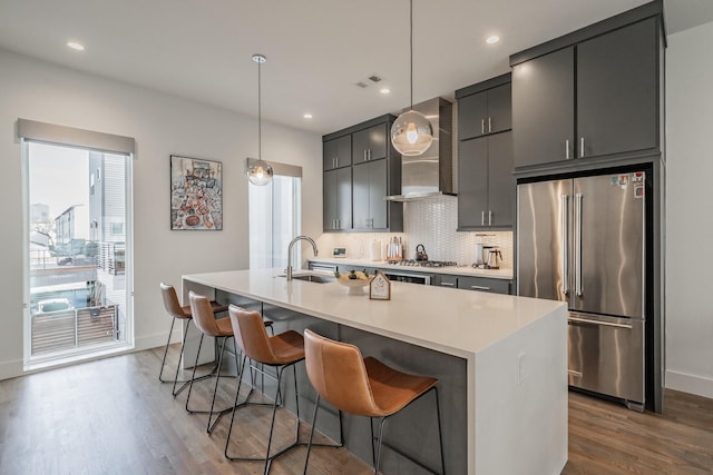 kitchen with a healthy amount of sunlight, visible vents, a sink, appliances with stainless steel finishes, and wall chimney range hood