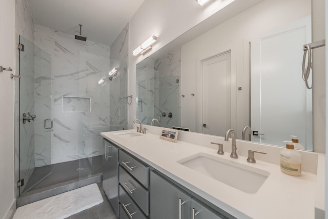 full bathroom featuring a marble finish shower, double vanity, and a sink