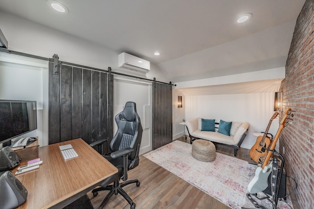 office space with brick wall, lofted ceiling, a barn door, wood finished floors, and a wall mounted AC