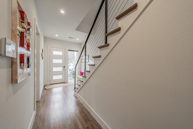 entrance foyer with recessed lighting, stairway, baseboards, and wood finished floors