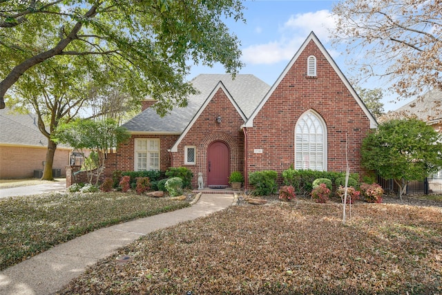 2740 Manorwood Trl, Fort Worth, TX 76109 - tudor-style house featuring brick siding, roof with shingles, and a chimney