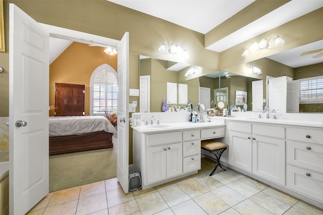 ensuite bathroom featuring a wealth of natural light, ensuite bath, and vanity