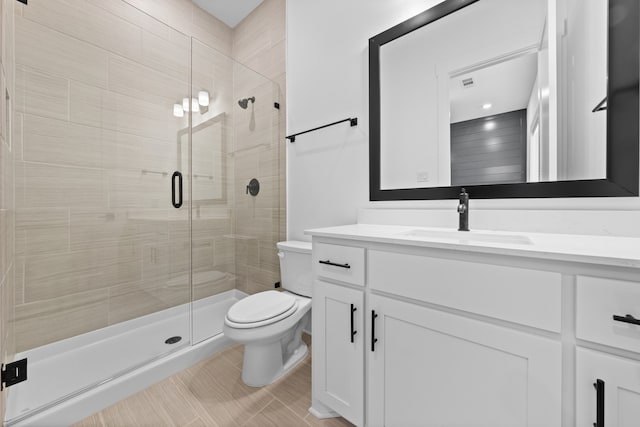 full bathroom with a shower stall, toilet, and vanity