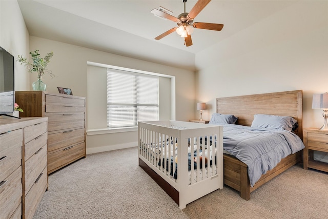 bedroom featuring light colored carpet, baseboards, and ceiling fan