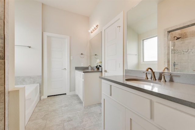 bathroom featuring tile patterned flooring, two vanities, a stall shower, a bath, and a sink