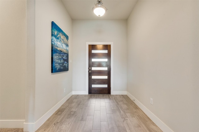 foyer with baseboards and light wood-style floors