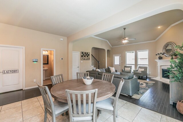 5113 Vieques Ln, Fort Worth, TX 76244 - tiled dining space featuring arched walkways, lofted ceiling, a ceiling fan, a glass covered fireplace, and stairway